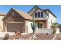 Charming home exterior with a two-car garage and desert landscaping at 14895 W Jenan Dr, Surprise, AZ 85379