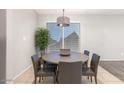 Bright dining room with a modern chandelier and a large window for natural light at 14919 W Hearn Cir, Surprise, AZ 85379