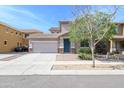 Charming two-story home with a two-car garage, desert landscaping, and a blue front door at 15450 W Laurel Ln, Surprise, AZ 85379