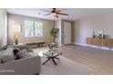 Bright living room featuring neutral walls, a ceiling fan, and stylish modern furniture at 15450 W Laurel Ln, Surprise, AZ 85379