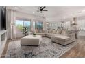 Open-concept living room with a sectional sofa, large windows and elegant decor at 16373 W Beautiful Ln, Goodyear, AZ 85338