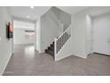 Inviting entryway featuring neutral tones, tile floors, and staircase leading to the upper level at 19026 W Becker Ln, Surprise, AZ 85388