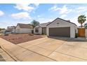 Single-story home with desert landscaping, gray roof, two-car garage and extended driveway at 19039 N 47Th Ave, Glendale, AZ 85308