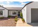 Inviting front entrance with desert landscaping, a gray roof, and a covered porch at 19039 N 47Th Ave, Glendale, AZ 85308