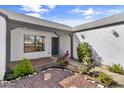 Inviting front entrance with desert landscaping, a gray roof, and a covered porch at 19039 N 47Th Ave, Glendale, AZ 85308