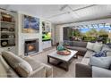 Inviting living room featuring a fireplace, comfortable seating, and seamless indoor-outdoor flow to the backyard at 19296 N 98Th Pl, Scottsdale, AZ 85255
