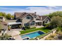 Beautiful home with a backyard oasis featuring a pool, lush greenery, and a pergola-covered dining area at 19296 N 98Th Pl, Scottsdale, AZ 85255