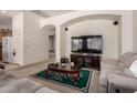 Open-concept living room featuring carpeted floors, arched doorways and a tv at 1955 E Grand Canyon Dr, Chandler, AZ 85249