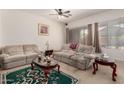 Comfortable living room featuring carpet, couches, a ceiling fan and natural light at 1955 E Grand Canyon Dr, Chandler, AZ 85249