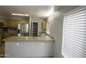 Kitchen features wood cabinets, stainless steel appliances and a bar at 20221 N 31St St, Phoenix, AZ 85050