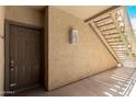Apartment entrance featuring a sturdy door, outdoor lighting, and convenient stair access to upper units at 2134 E Broadway Rd # 1062, Tempe, AZ 85282