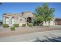 Inviting single-story home featuring desert landscaping, a circular turret entry, and an attached three-car garage at 22709 S 202Nd St, Queen Creek, AZ 85142
