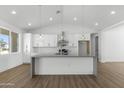 Open concept kitchen features modern white cabinets, gray countertops, stainless appliances, and pendant lighting at 2689 S 305Th Ave Ave, Buckeye, AZ 85326