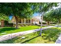 Beautiful single-story home with a well-kept lawn, inviting porch, and a charming tree-lined street at 2879 E Austin Dr, Gilbert, AZ 85296