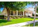 Inviting single-story home with a manicured lawn, inviting porch, and a charming tree at 2879 E Austin Dr, Gilbert, AZ 85296