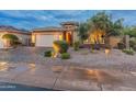Charming single-story home featuring desert landscaping, a two-car garage, and stone accents at 31207 N 124Th Dr, Peoria, AZ 85383
