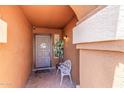 Covered front porch entry featuring tile flooring, a chair, and a plant at 3424 E Harmony Ave, Mesa, AZ 85204