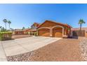 A home with a three-car garage, desert landscaping, and a beautiful facade at 3424 E Harmony Ave, Mesa, AZ 85204