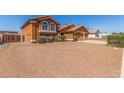 A home with a large yard featuring desert landscaping and an orange exterior at 3424 E Harmony Ave, Mesa, AZ 85204