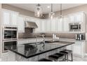 Modern kitchen with white cabinets, granite countertops, stainless steel appliances, and an island with barstool seating at 5428 E Windstone Trl, Cave Creek, AZ 85331