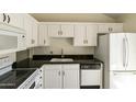 Bright kitchen featuring white cabinetry, black countertops, and modern appliances at 5622 N Palacio Way, Phoenix, AZ 85014