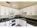 Bright kitchen featuring white cabinetry, black countertops, and stainless steel appliances at 5622 N Palacio Way, Phoenix, AZ 85014