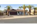 Attractive single-story home with a two-car garage, desert landscaping and mature palm trees at 5802 E Spring Rd, Scottsdale, AZ 85254