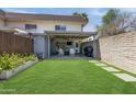Well-manicured backyard with covered patio, grill, and lush green lawn at 8135 N Central Ave # 1, Phoenix, AZ 85020