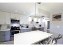 Modern kitchen featuring stainless steel appliances, white cabinets, and an island with a breakfast bar at 8135 N Central Ave # 1, Phoenix, AZ 85020