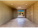 An empty room has earth-toned walls, a concrete floor and a view to the outdoors at 8752 E Range Rider Trl, Mesa, AZ 85207