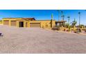 Suburban home features a gravel driveway, three car garage, and desert landscaping at 8752 E Range Rider Trl, Mesa, AZ 85207