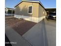 View of a light tan single-story home, with easy-to-maintain gravel landscaping and a covered parking space at 8832 E Pueblo Ave # 20, Mesa, AZ 85208