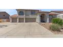 Charming home with a three car garage and a well-manicured lawn on a sunny day at 9548 W Keyser Dr, Peoria, AZ 85383