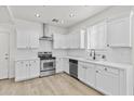 Modern kitchen with white cabinetry, stainless steel appliances and fixtures, and wood-style flooring at 1225 N 36Th St # 1015, Phoenix, AZ 85008