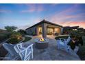 Outdoor living space with travertine patio, fire pit, seating and built-in grill at 13236 W Montansoro Ln, Peoria, AZ 85383