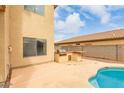 Backyard view showing pool, outdoor grill and counter, and the home's exterior at 13443 W Crocus Dr, Surprise, AZ 85379