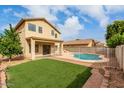 Home's backyard featuring a pool, artificial turf, and patio area, great for outdoor living at 13443 W Crocus Dr, Surprise, AZ 85379