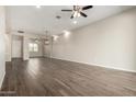 Spacious living room with tile flooring, neutral walls, recessed lighting, ceiling fan, and open access to the adjacent room at 14045 W Desert Flower Dr, Goodyear, AZ 85395