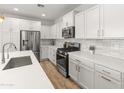 Stylish kitchen with stainless steel appliances, white cabinets, and a modern island at 14435 W El Cortez Pl, Surprise, AZ 85387