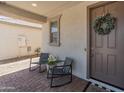 Inviting front porch with seating and a decorative wreath on the front door at 14435 W El Cortez Pl, Surprise, AZ 85387