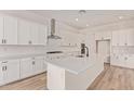Bright kitchen features white cabinets, a spacious island, and modern stainless steel appliances at 15833 W Bronco Trl, Surprise, AZ 85387