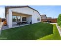 Outdoor living space includes artificial turf, covered patio with furniture, and privacy fencing at 27510 N 30Th Ln, Phoenix, AZ 85083