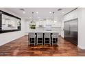 Bright kitchen features hardwood floors, stainless appliances, marble countertops, and a kitchen island with seating at 4021 E Glenrosa Ave, Phoenix, AZ 85018