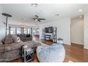 Spacious living room featuring hardwood floors, a comfortable sectional sofa, and a modern ceiling fan at 4402 E Montecito Ave, Phoenix, AZ 85018