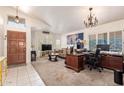 Spacious living room with plush carpeting, bright natural light, and elegant chandelier at 4441 E Desert Wind Dr, Phoenix, AZ 85044