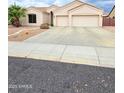 Wide driveway leading to a two-car garage, complemented by desert landscaping at 4628 W Whispering Wind Dr, Glendale, AZ 85310