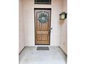 Elegant wooden front door adorned with a wreath, adding a welcoming touch to the entrance at 4628 W Whispering Wind Dr, Glendale, AZ 85310