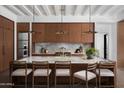 The kitchen island offers barstool seating, stylish pendant lighting, and beautiful views of the backyard at 4864 E Lafayette Blvd, Phoenix, AZ 85018