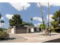 Beautiful single-story home featuring desert landscaping, palm trees, and modern architectural details at 5341 E Sheena Dr, Scottsdale, AZ 85254