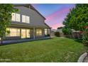 Beautiful backyard boasts an expansive lawn, mature trees, and a covered patio at 664 E Windsor Dr, Gilbert, AZ 85296